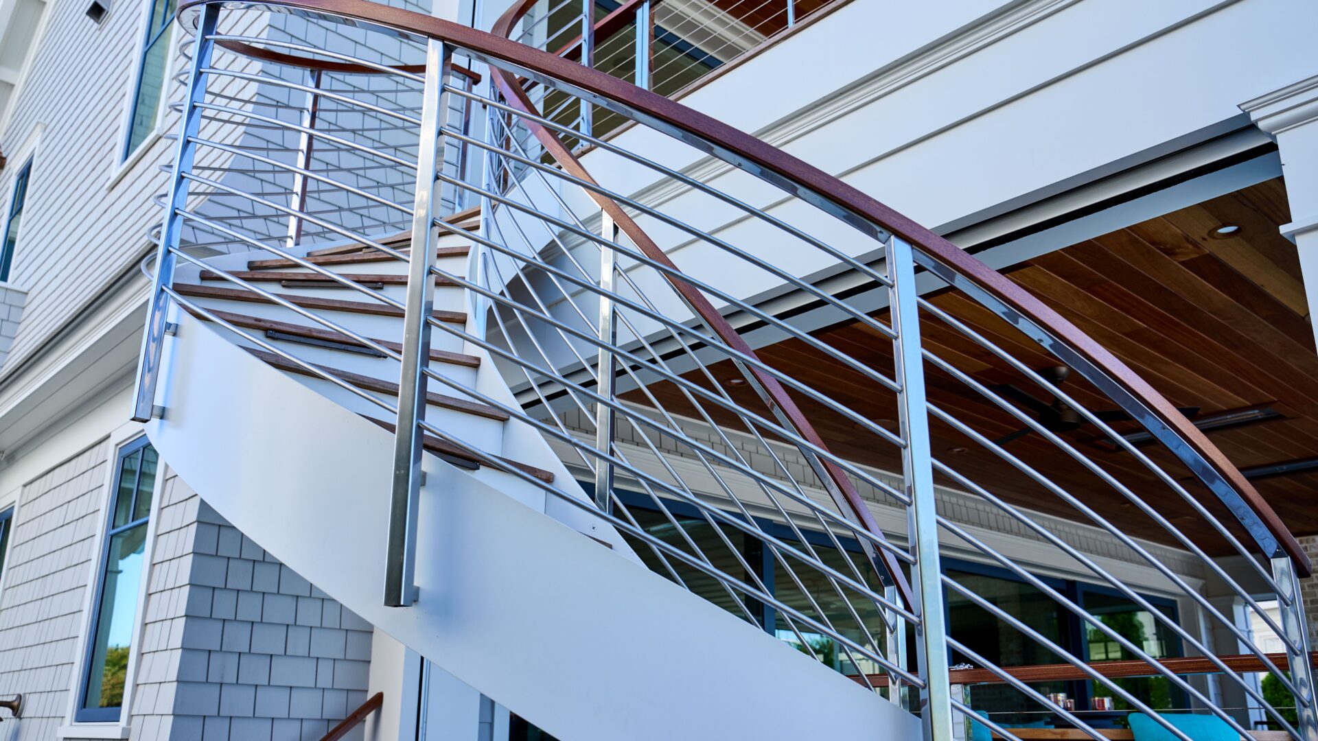 Sleek helical staircase with polished stainless steel railing, offering a modern and sophisticated appearance
