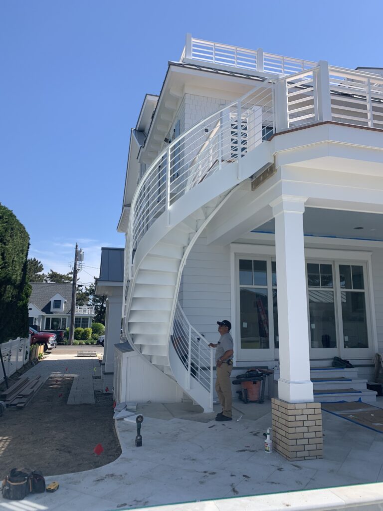 White designer staircase creating a disjointed curve from the first floor to second story terrace.